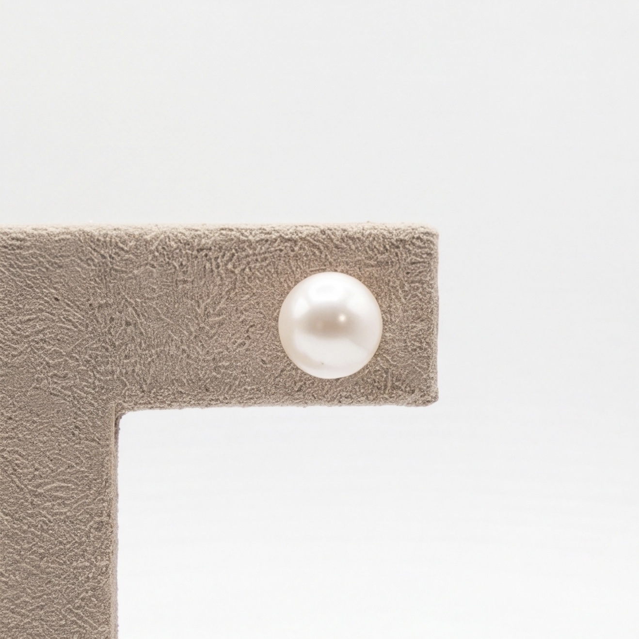 Close-up of a single white round freshwater pearl stud earring - Pure Pearls